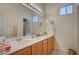 Bathroom with dual sinks, a large mirror, and updated lighting fixtures offers comfort and convenience at 9843 Wonderful Day Dr, Las Vegas, NV 89148