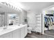 Bright bathroom with double sinks, modern fixtures, and adjacent walk-in closet at 2152 Quarry Ridge St # 106, Las Vegas, NV 89117