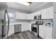 Bright kitchen featuring white cabinets, stainless steel appliances, and wood-look flooring at 2152 Quarry Ridge St # 106, Las Vegas, NV 89117