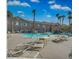 Community pool with lounge chairs, tables and beautiful palm trees at 2152 Quarry Ridge St # 106, Las Vegas, NV 89117