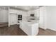 White kitchen with island, stainless steel appliances and view to stairs at 10328 Apefly St, Las Vegas, NV 89141