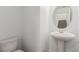 Clean powder room with pedestal sink and round mirror at 10328 Apefly St, Las Vegas, NV 89141