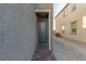 Side view of house with dark gray door and brick pathway at 10328 Apefly St, Las Vegas, NV 89141