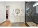 Bathroom with vanity, glass shower, wood-look floors, and an open door to a large, organized walk-in closet at 10420 Luella Ct, Las Vegas, NV 89143