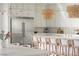 Close-up of the modern kitchen island featuring white marble countertops and stylish woven bar stools at 10420 Luella Ct, Las Vegas, NV 89143