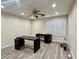 Bedroom featuring wood floors, a ceiling fan, a window with white shutters, and desks at 10618 Timber Stand St, Las Vegas, NV 89183