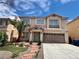 Charming two-story home featuring a desert landscaped front yard with a two car garage and light tan paint at 10618 Timber Stand St, Las Vegas, NV 89183