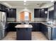 Modern kitchen featuring dark cabinetry, granite countertops, stainless steel appliances, and a center island at 10618 Timber Stand St, Las Vegas, NV 89183