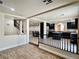 Open-concept space with wood-look floors, a staircase, and a view of the kitchen with dark cabinets at 10618 Timber Stand St, Las Vegas, NV 89183