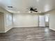 Bright living room featuring new wood floors, a ceiling fan, and white trim at 10618 Timber Stand St, Las Vegas, NV 89183