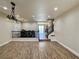 Spacious living room featuring wood-look floors, decorative lighting, and a view of the staircase and dining area at 10618 Timber Stand St, Las Vegas, NV 89183