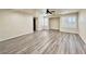 Expansive living room featuring wood-look floors, recessed lighting, and shuttered windows for natural light at 10618 Timber Stand St, Las Vegas, NV 89183