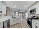 Spacious open kitchen with modern white cabinets, stainless appliances, quartz counters, and wood-look flooring at 1106 Emerald Stone Ave, North Las Vegas, NV 89081