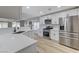 Bright kitchen features stainless steel appliances, white cabinets, quartz countertops, and wood-look flooring at 1106 Emerald Stone Ave, North Las Vegas, NV 89081