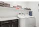 Well-organized laundry room with shelving, modern washer and dryer, and ample counter space at 1209 Crystal Grotto Ave, North Las Vegas, NV 89081