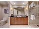 A bathroom featuring double sinks, a large mirror, and a glass-enclosed shower at 135 E Harmon Ave # 817, Las Vegas, NV 89109