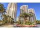 Stunning high-rise towers complemented by lush landscaping and swaying palm trees against a vibrant blue sky at 135 E Harmon Ave # 817, Las Vegas, NV 89109