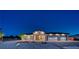 Night shot of a single-story home with a three car garage and manicured landscaping at 1691 Blackhorn St, Pahrump, NV 89048