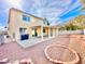 View of the home's backyard showing gravel landscaping, patio area, and tan two-story home at 1838 Fighting Falcon Ln, North Las Vegas, NV 89031