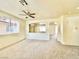 Open-concept living room with neutral carpet, a ceiling fan, and natural light from large windows at 1838 Fighting Falcon Ln, North Las Vegas, NV 89031