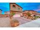 Two-story house with a landscaped front yard and attached garage, on a quiet street at 200 Denette Ln, North Las Vegas, NV 89031