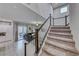 Carpeted staircase with dark wood and white railings, overlooking the living room and kitchen at 200 Denette Ln, North Las Vegas, NV 89031