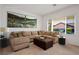 Virtually staged living room with L-shaped sectional sofa and large windows at 2127 Sawtooth Mountain Dr, Henderson, NV 89044