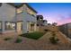 Backyard with covered patio, artificial grass, rock landscaping, and view of adjacent houses at 2384 Ridgeline Wash St, Las Vegas, NV 89138