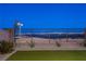 Backyard with artificial turf, rock landscaping, and a distant view of the city skyline at 2384 Ridgeline Wash St, Las Vegas, NV 89138