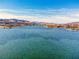 Panoramic view of a lake surrounded by waterfront homes, mountains, and blue skies at 24 Cerchio Alto, Henderson, NV 89011