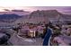 Overhead view of luxury villas showcases lush landscaping, tiled roofs, and scenic mountain backdrop, promoting community living at 24 Cerchio Alto, Henderson, NV 89011