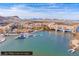 Panoramic aerial view of lakeside resort with buildings, boats, a dock, a bridge, and desert mountain views at 24 Cerchio Alto, Henderson, NV 89011