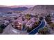 Stunning aerial view of luxury villas with red tile roofs and a community pool nestled in a mountainous landscape at 24 Cerchio Alto, Henderson, NV 89011