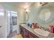 Bathroom featuring double sinks with granite countertops, a shower-tub combo, and updated lighting fixtures at 2727 Scotch Heather St, Las Vegas, NV 89142