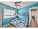 The bedroom has a bunk bed, wood floors, a ceiling fan, a window with blinds and light-blue painted walls at 2727 Scotch Heather St, Las Vegas, NV 89142