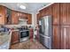 Updated kitchen with stainless steel refrigerator and range, granite countertops, and dark wood cabinets at 2727 Scotch Heather St, Las Vegas, NV 89142