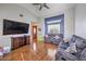 Spacious living room with vaulted ceilings, hardwood floors, large TV, and blue accent wall with white molding at 2727 Scotch Heather St, Las Vegas, NV 89142