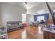 Open living space featuring wood floors, vaulted ceilings, blue accent wall, a dining area, and access to the stairs at 2727 Scotch Heather St, Las Vegas, NV 89142