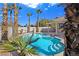 Backyard pool area featuring a sparkling pool, palm trees, and a covered patio at 283 Fancrest St, Henderson, NV 89052