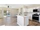 Open concept kitchen with white cabinets, stainless steel appliances, and an island overlooking the living area at 283 Fancrest St, Henderson, NV 89052