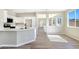 Open kitchen with white cabinets and countertop bar looking into the large, bright living room at 283 Fancrest St, Henderson, NV 89052