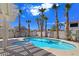 Backyard oasis featuring a sparkling pool surrounded by lush palm trees at 283 Fancrest St, Henderson, NV 89052