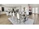 Elegant dining room features a glass table and modern chairs, adjacent to kitchen at 3 Hilltop Crest St, Henderson, NV 89011