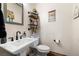 Charming half-bathroom featuring a pedestal sink, modern faucet, and rustic decor at 3101 S Spy Glass Ave, Pahrump, NV 89048