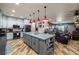 Open-concept kitchen flowing into a cozy living area, adorned with red pendant lights above the island at 3101 S Spy Glass Ave, Pahrump, NV 89048