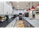 Spacious kitchen featuring granite countertops, stainless steel appliances, and stylish red pendant lights at 3101 S Spy Glass Ave, Pahrump, NV 89048