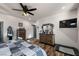 Comfortable main bedroom features wood-look floors, ceiling fan, and a dresser with ornate mirror at 3101 S Spy Glass Ave, Pahrump, NV 89048