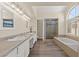 Bright bathroom with double sinks, granite counters, shower, and soaking tub at 3305 Cutty Sark St, Las Vegas, NV 89117