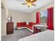 Bedroom with red couch, desk, and window with red curtains at 3398 El Camino Real, Las Vegas, NV 89121