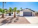 Inviting home exterior featuring palm trees, a gravel yard, and an attached two-car garage at 3625 Winner Dr, Las Vegas, NV 89120